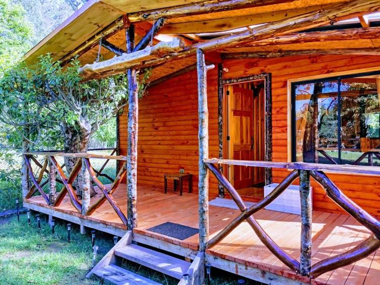 a wooden cabin with a porch and a staircase to it at Cabaña GAROVE in Panguipulli