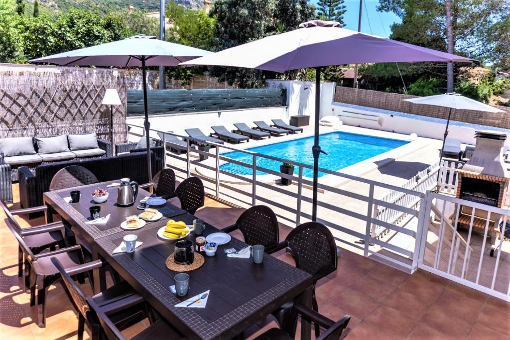 a patio with tables and chairs next to a swimming pool at Villa Montesol in La Drova