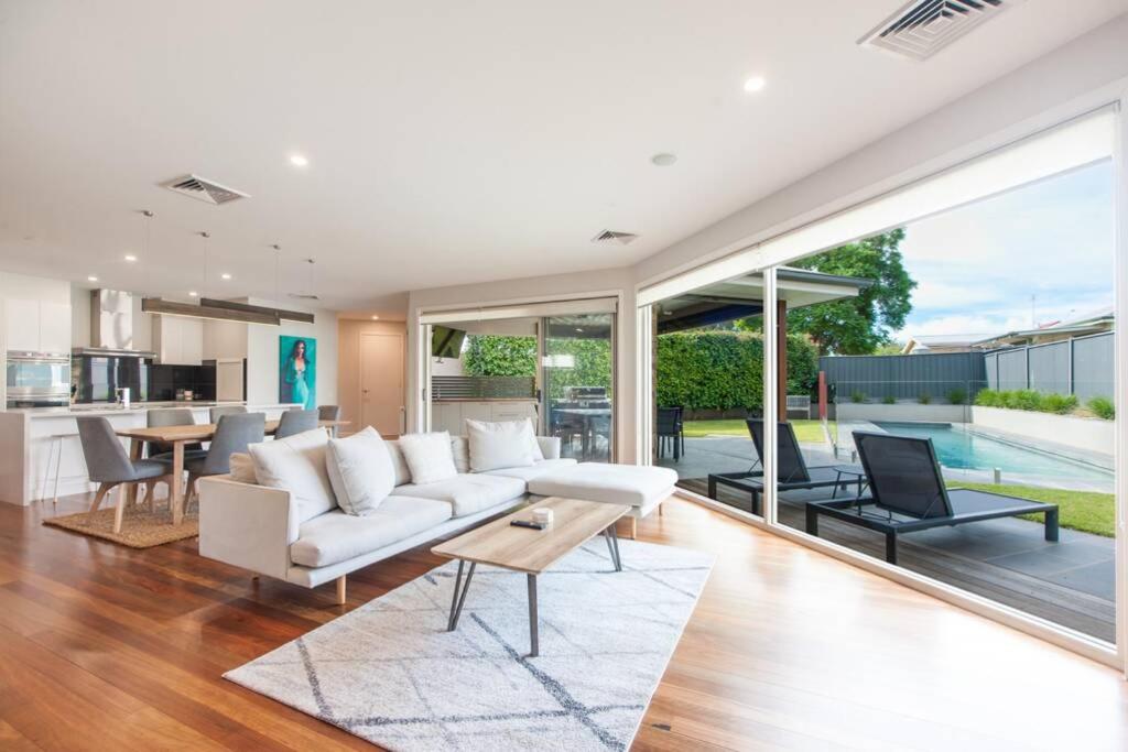 a living room with a white couch and a table at Blair Street - Luxury Home with Pool and Theatre in Moama
