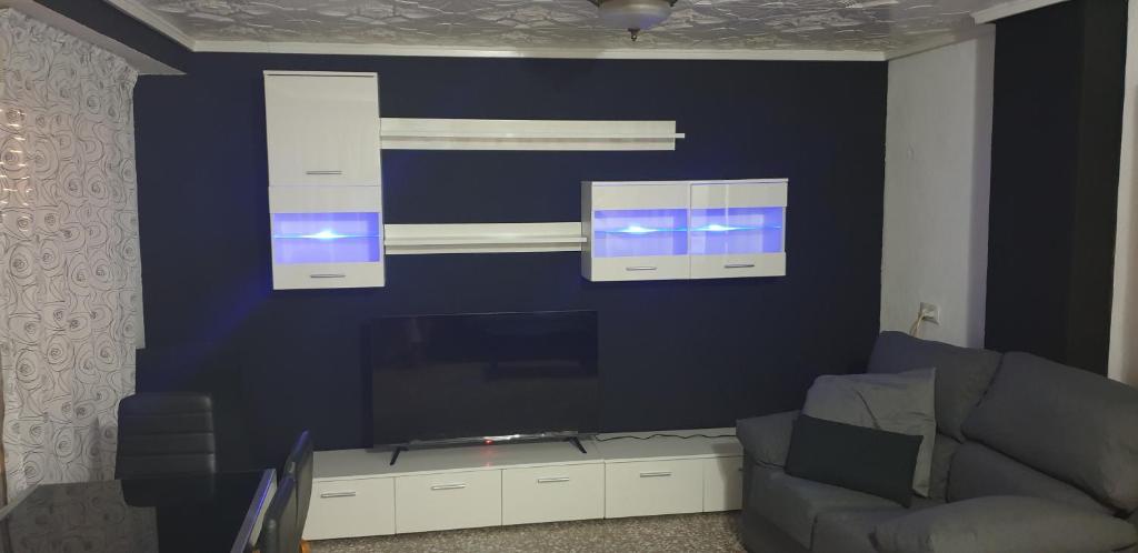 a living room with a couch and a large screen tv at Casa Erick in Elche