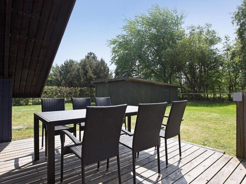 a table and chairs on a wooden deck at 5 person holiday home in Dannemare in Dannemare