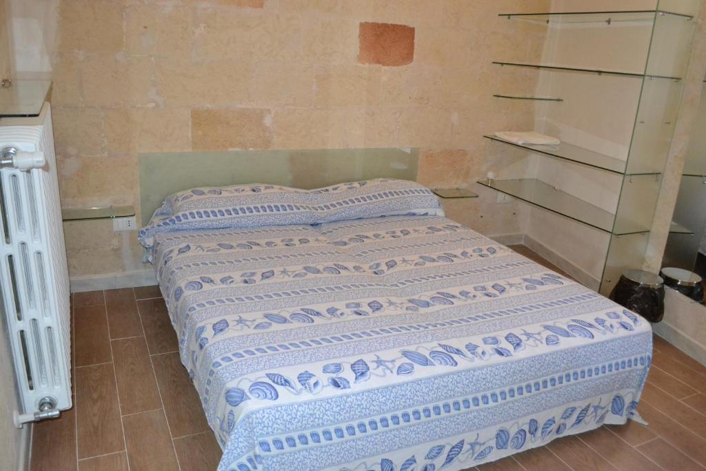 a bed in a room with glass shelves at Depandance Economy in Manduria