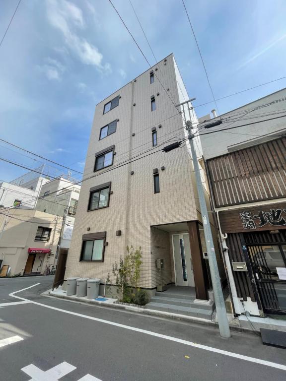 ein hohes Backsteingebäude am Straßenrand in der Unterkunft PRISM INN Asakusa in Tokio