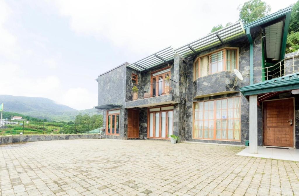 a building with a stone driveway in front of it at HummingBird Hill Cottage in Nuwara Eliya