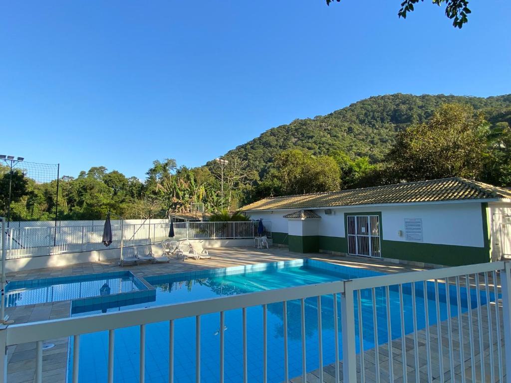 ein Pool vor einem Haus mit einem Berg in der Unterkunft AP COM PISCINA, CHURRASQUEIRAS, AR CONDICIONADO, até 08 adultos in Ubatuba