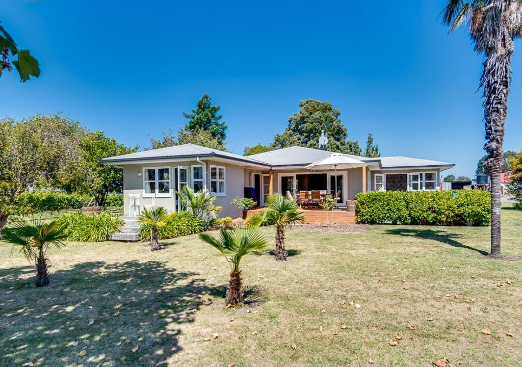 a house with palm trees in front of it at The Farmhouse in Napier