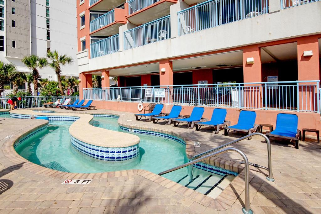 a swimming pool with blue chairs in a building at Roxanne Towers 1101 in Myrtle Beach