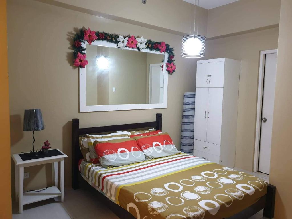 1 dormitorio con cama y espejo grande en Pico de Loro Staycation (3 beds- 6 pax) en Nasugbu