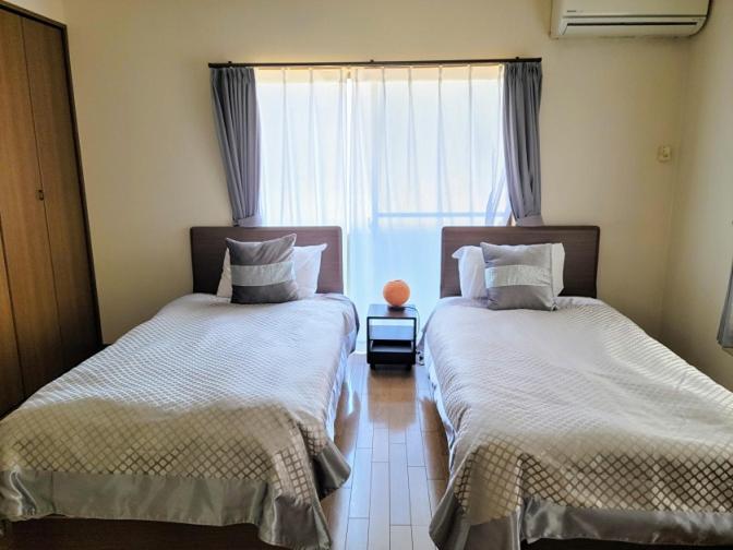 two beds in a room with a window at Episode1 in Naoshima
