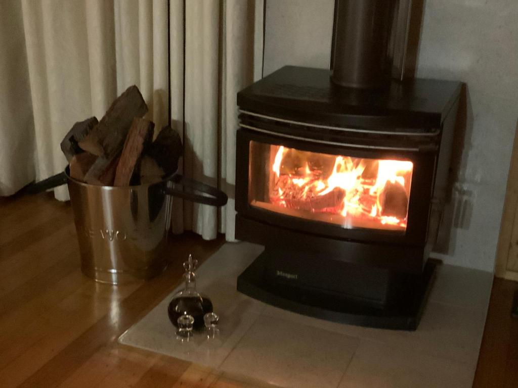 a stove sitting on the floor with a fire in it at Belle's at Montville in Montville