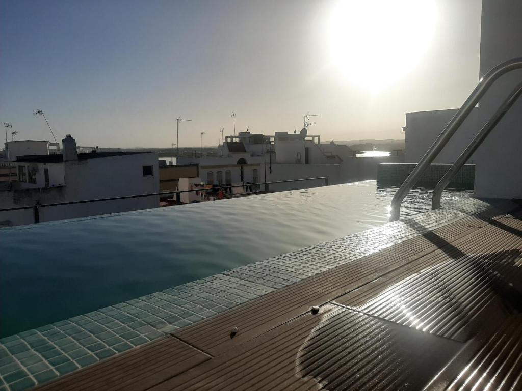 een uitzicht op het dak van een gebouw met de zon bij LUXURY APARTAMENTOS Doña Bella in Ayamonte