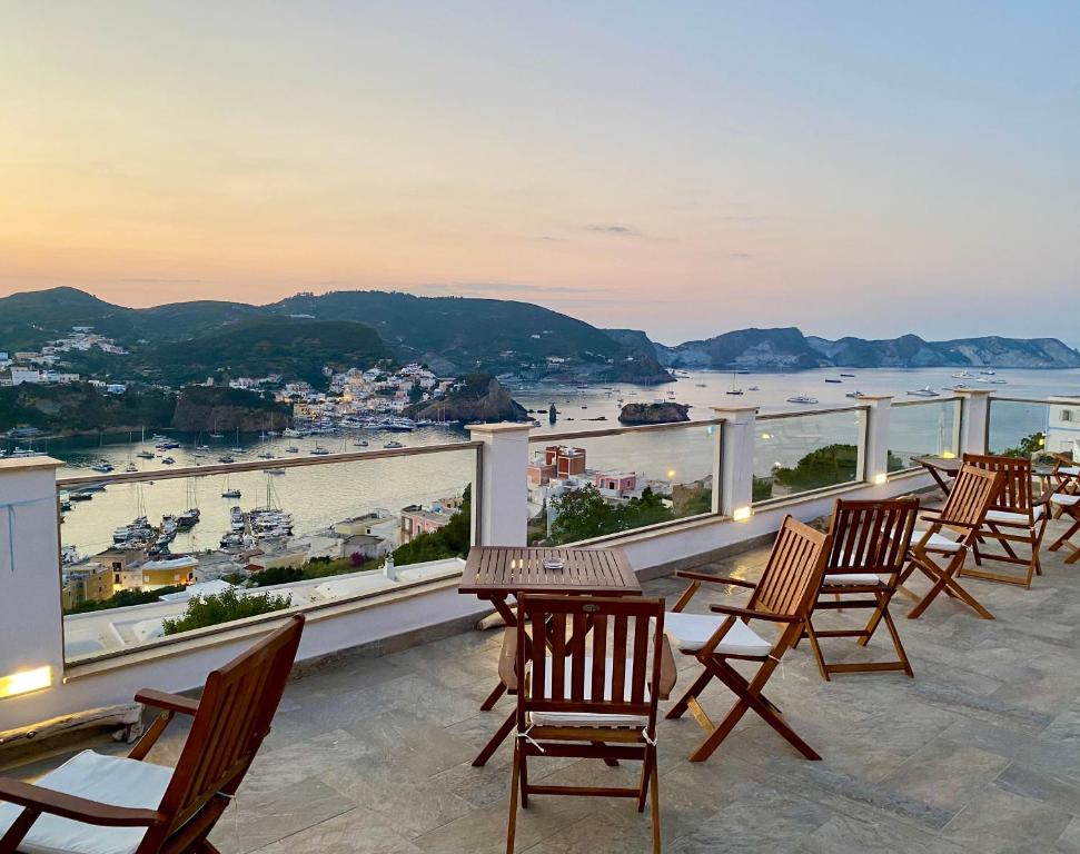 a balcony with chairs and tables and a view of a harbor at Domus Ɫ Ponza SeaView in Ponza