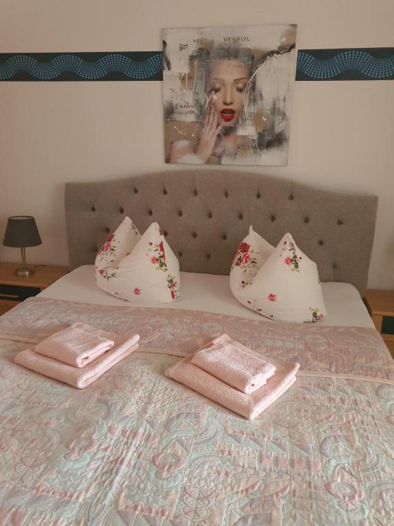Una cama con toallas rosas encima. en Große Ferienwohnung 85qm en Havelberg