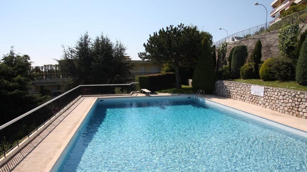 - une piscine dans une cour à côté d'un bâtiment dans l'établissement 3 pièces vue mer et piscine quartier Parc Impérial, à Nice