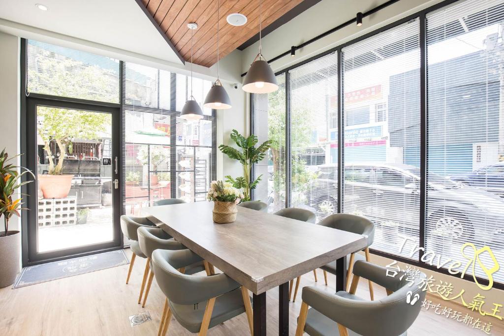 a dining room with a table and chairs and windows at Go Around House in Hualien City