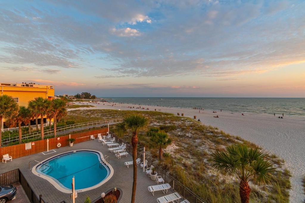 a resort with a swimming pool and a beach at Beachfront Madeira Norte in St. Pete Beach