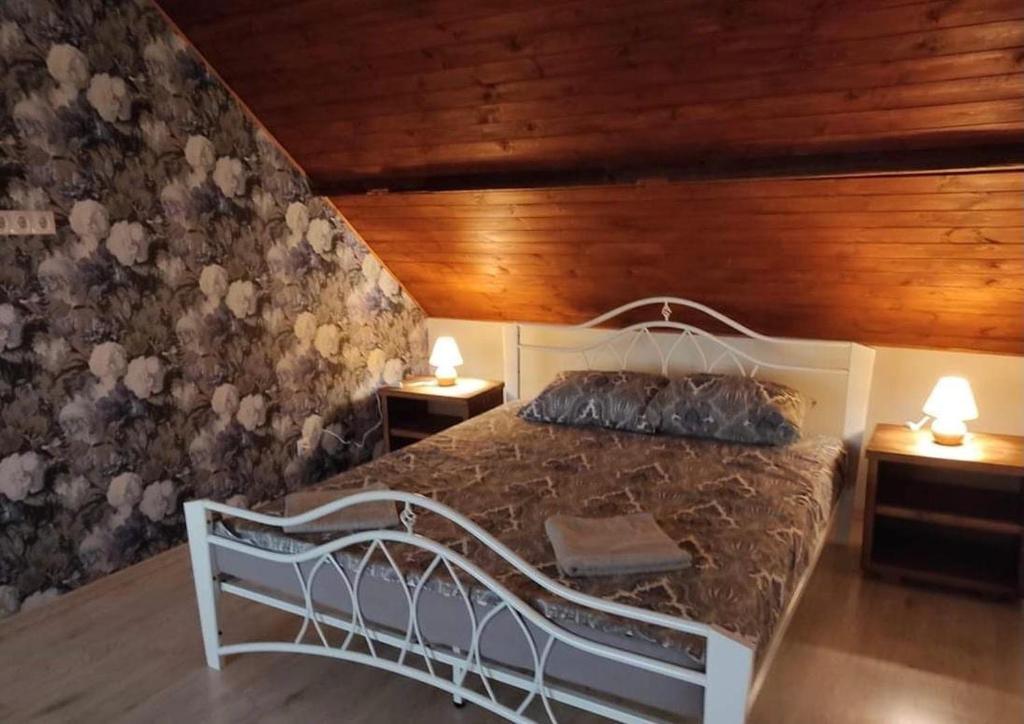 um quarto com uma cama branca e duas mesas de cabeceira em Vilnīši em Ulmale