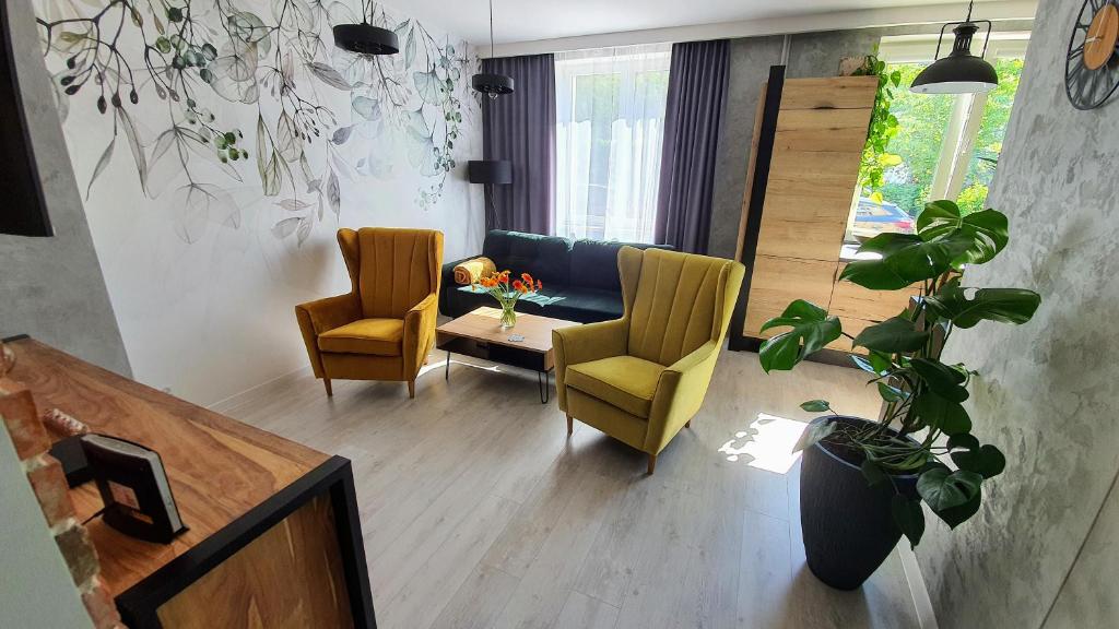 a living room with two chairs and a table at Apartament Garncarska in Elblag