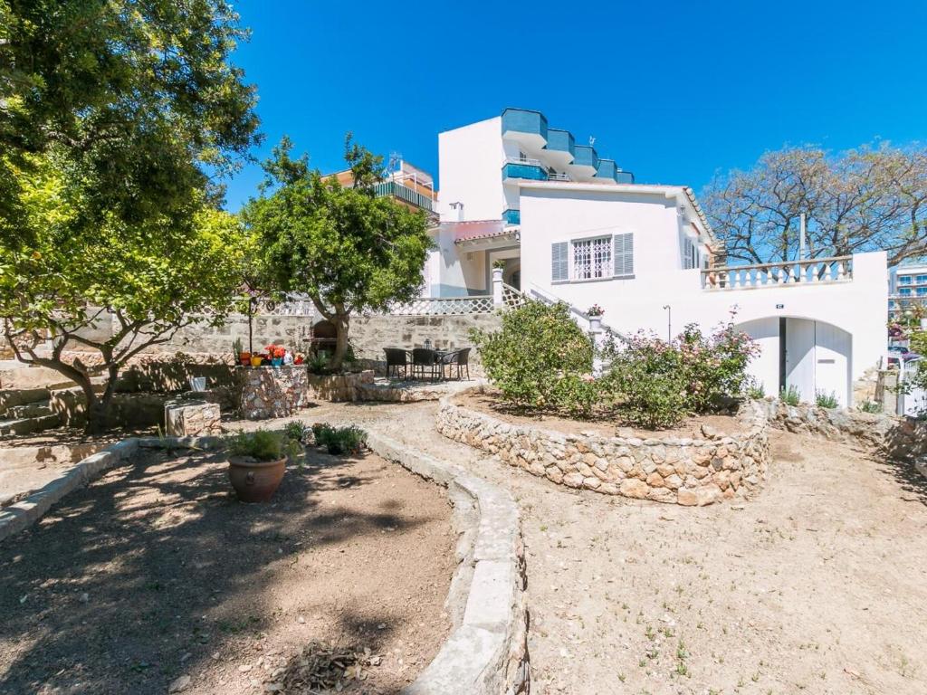 duży biały dom z drzewami przed nim w obiekcie Villa los brezos w mieście Playa de Palma