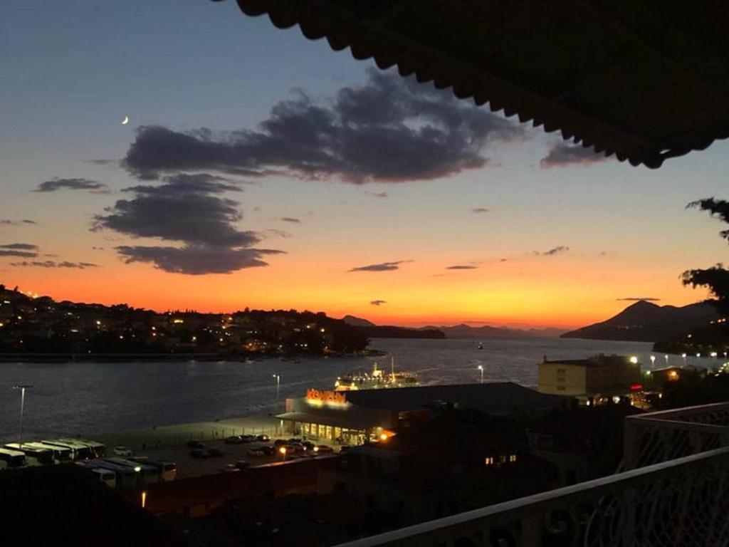 a sunset over a body of water with a city at Apartments Tayra in Dubrovnik