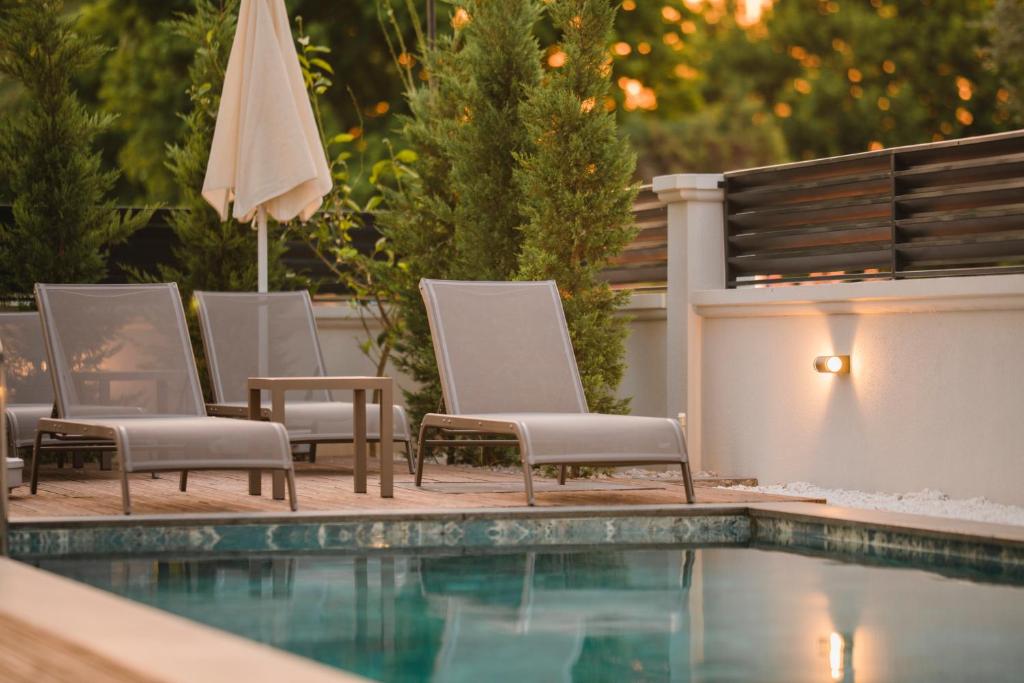 a group of chairs and an umbrella next to a swimming pool at Avilia Suites in Fethiye