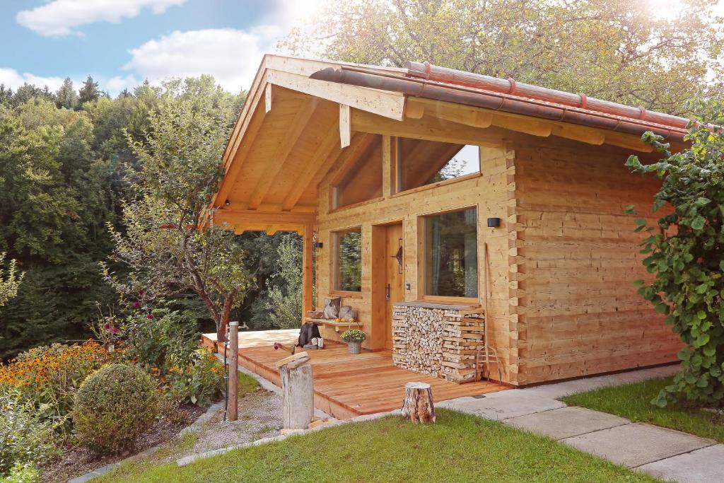 a log cabin with a deck in a garden at Das Alm-Chalet-Chiemsee in Bernau am Chiemsee