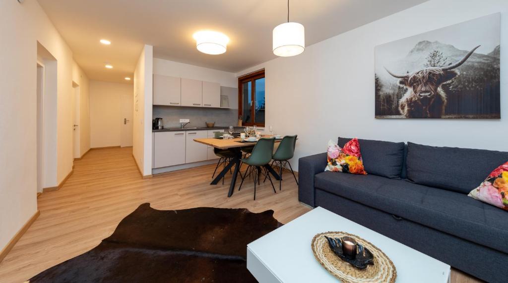 格拉茲的住宿－Suiten am Rosenberg，客厅配有蓝色的沙发和桌子