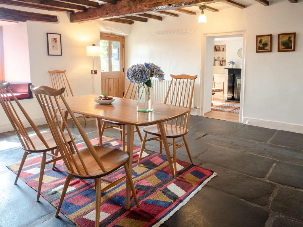 a dining room with a wooden table and chairs at Wayside Cottage 1637 in Millom