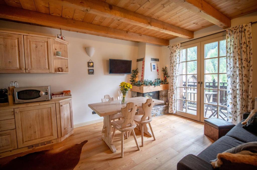 a kitchen with a wooden table and a dining room at TRILOCALE ALPES: DIMENTICA L'AUTO E RILASSATI in Ponte di Legno