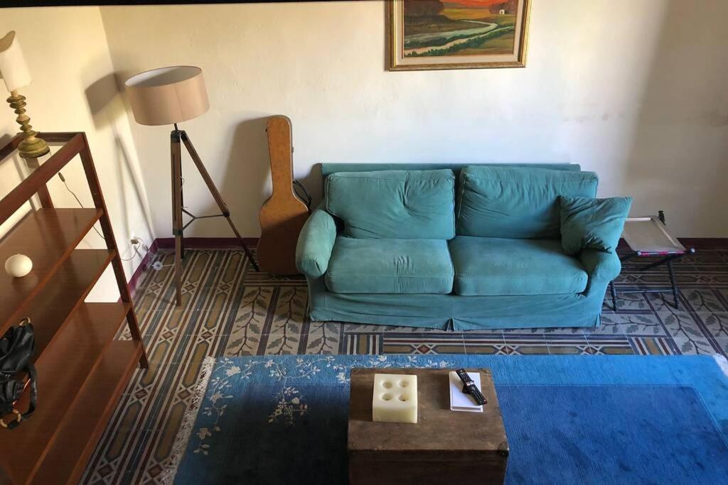 Una sala de estar con un sofá azul y una mesa. en Casina Marina, en Marina di Pisa