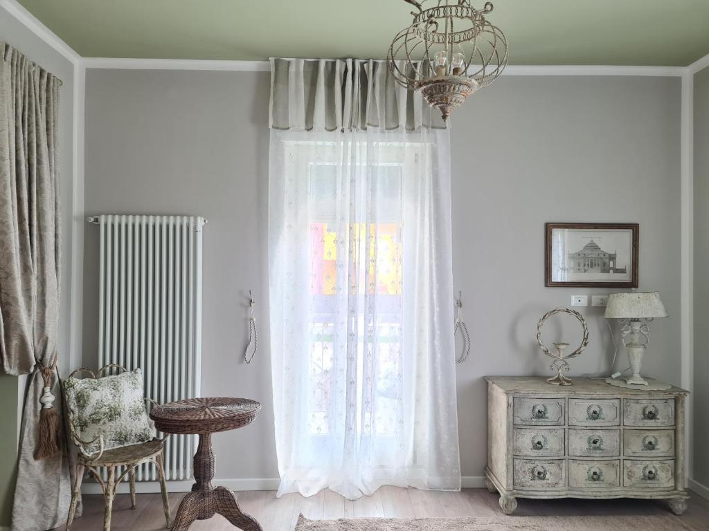 a room with a window with a dresser and a chandelier at Sofia's Cottage in Sommacampagna