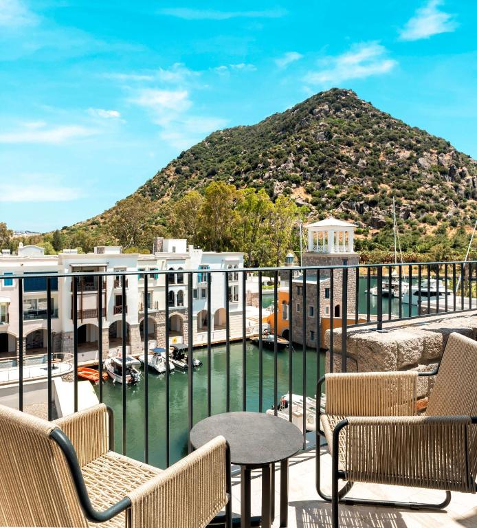 a balcony with chairs and a view of a mountain at Radisson Collection Hotel, Bodrum in Akyarlar
