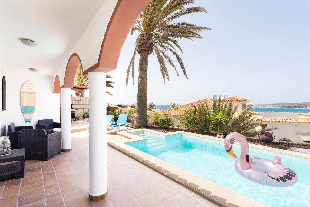 una piscina con un flamenco rosa en una villa en Casa Platano - Private pool - Ocean View - BBQ - Garden - Terrace - Free Wifi - Child & Pet-Friendly - 4 bedrooms - 8 people, en Porís de Abona