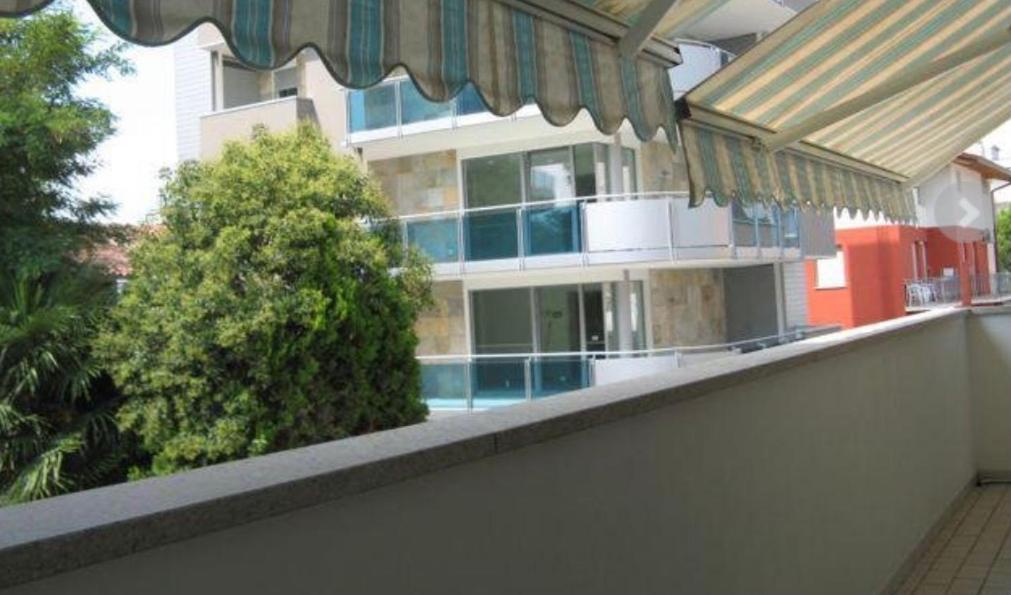 a balcony with a building in the background at Villa Rosa in Lignano Sabbiadoro