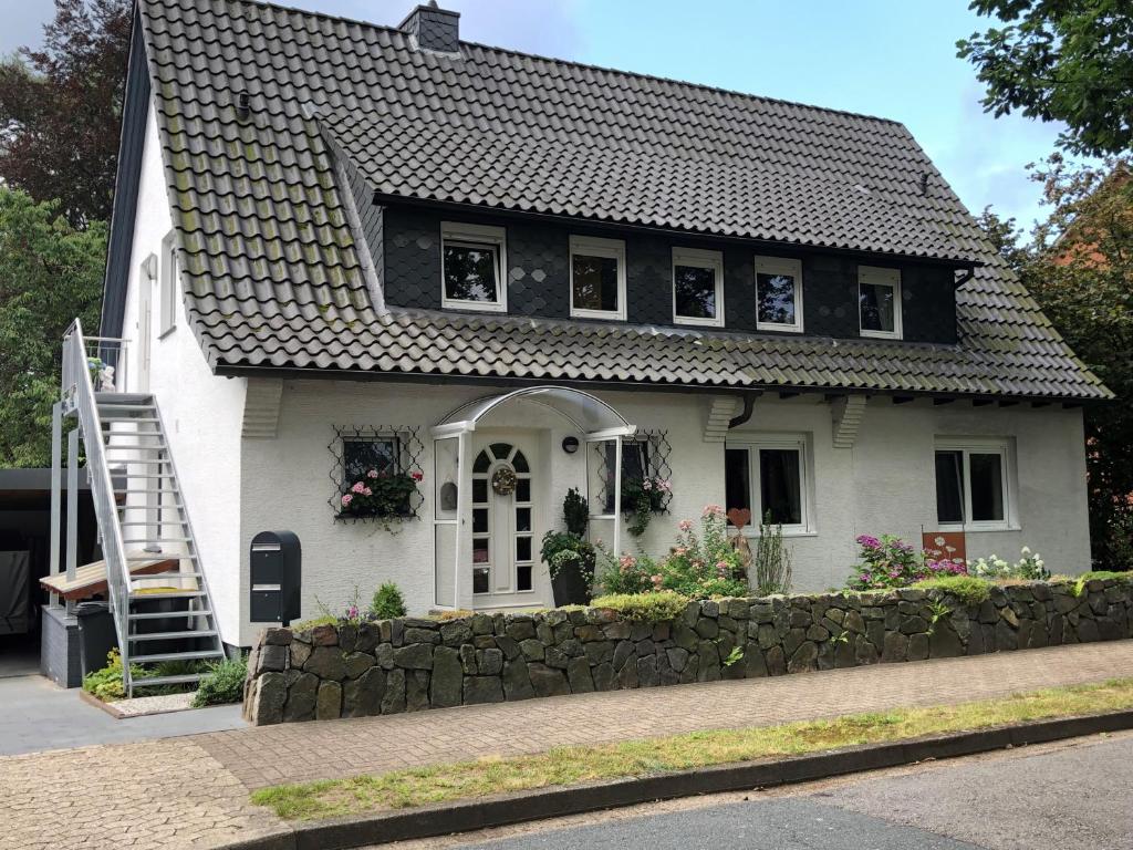 a small white house with a stone wall at Ferienwohnung Reiners in Schneverdingen