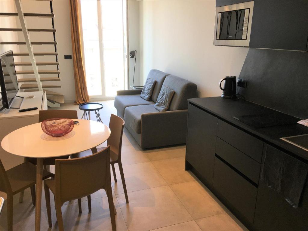Il dispose d'une cuisine et d'un salon avec une table et un canapé. dans l'établissement Duplex balcon centre mer 502, à Nice