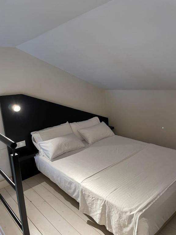 a bedroom with a white bed with a black headboard at Hacienda Soto-Hego Haizea in Chiclana de la Frontera
