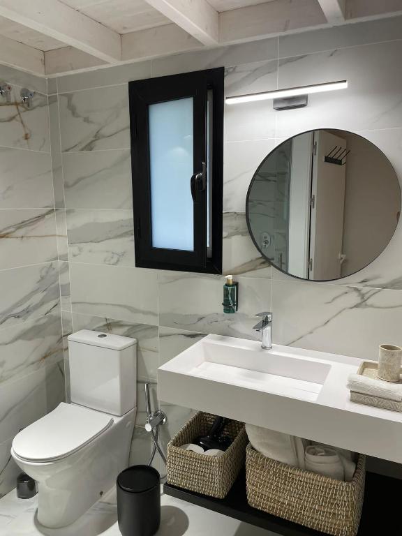 a bathroom with a toilet and a sink and a mirror at Hacienda Soto-Hego Haizea in Chiclana de la Frontera