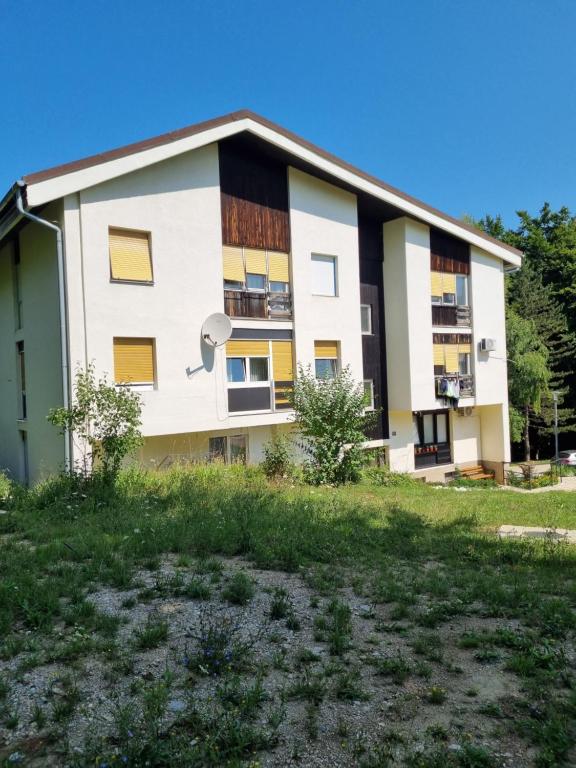 un immeuble d'appartements jaune et blanc dans l'établissement Apartments Nada & Yoya, aux lacs de Plitvice