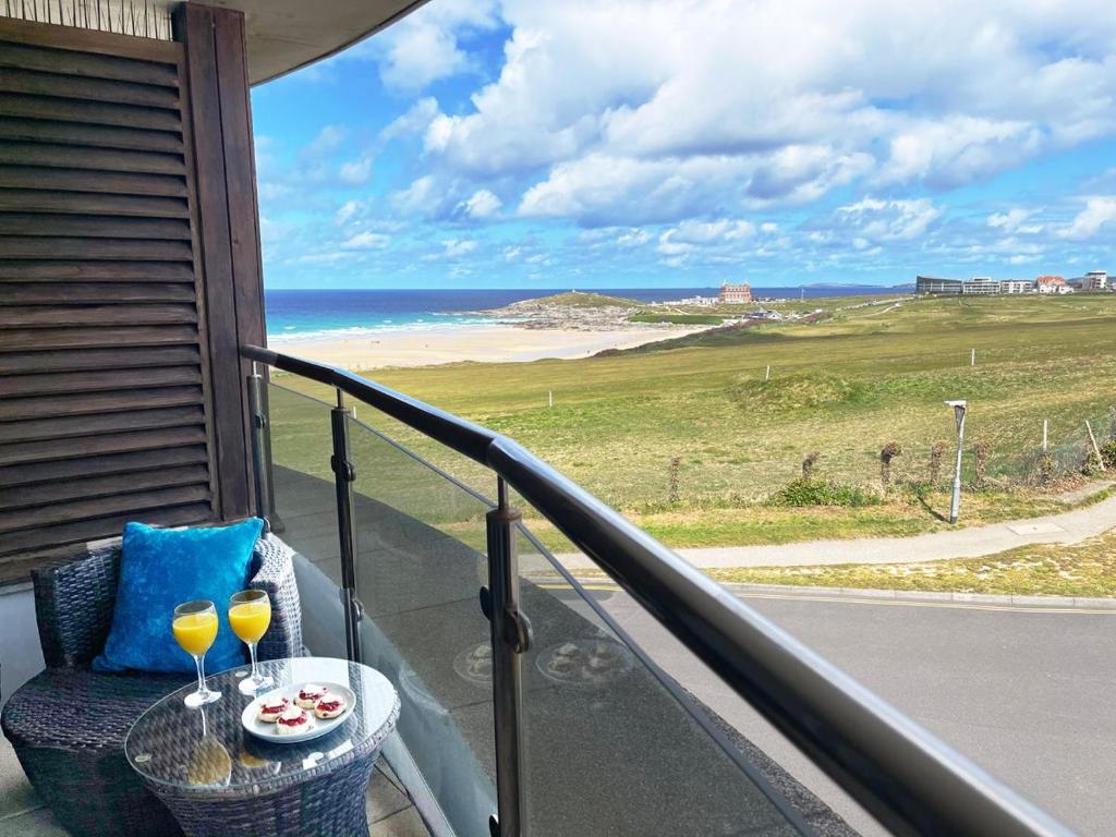 a balcony with a table and two wine glasses at Ocean Gate 24 in Newquay