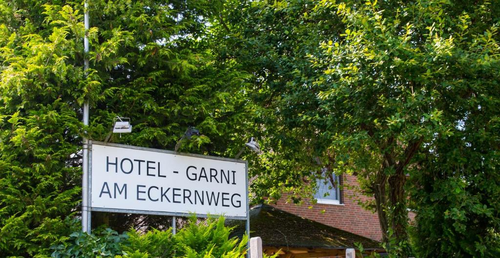un cartel frente a una casa con árboles en Hotel Garni am Eckernweg, en Celle