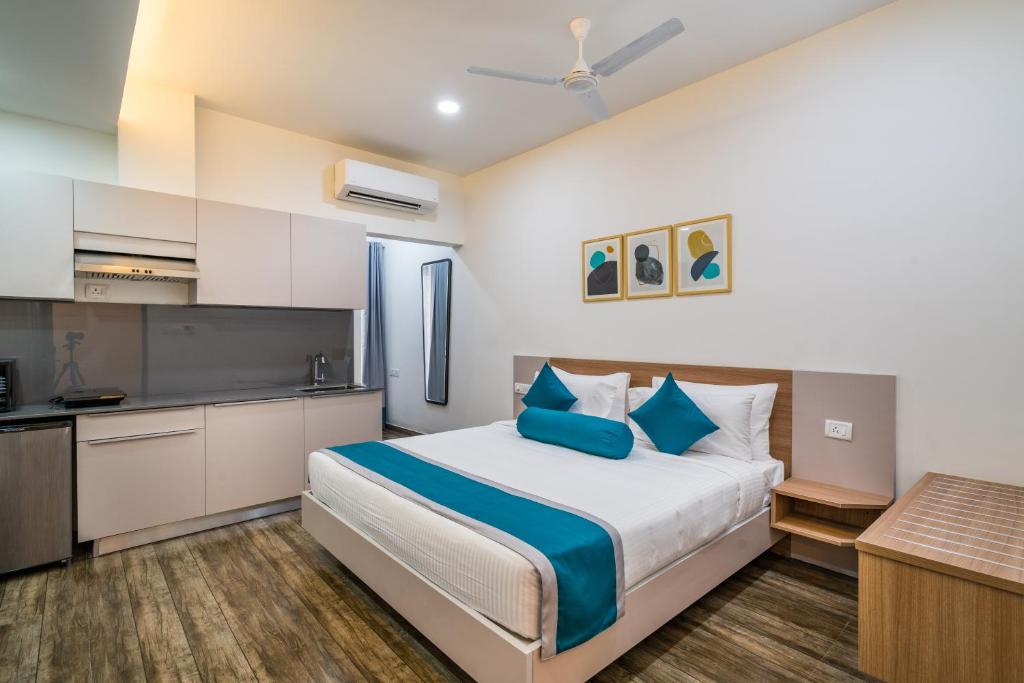 a bedroom with a large bed and a kitchen at SKYLA Serviced Apartments & Suites, Hi-Tech City in Hyderabad