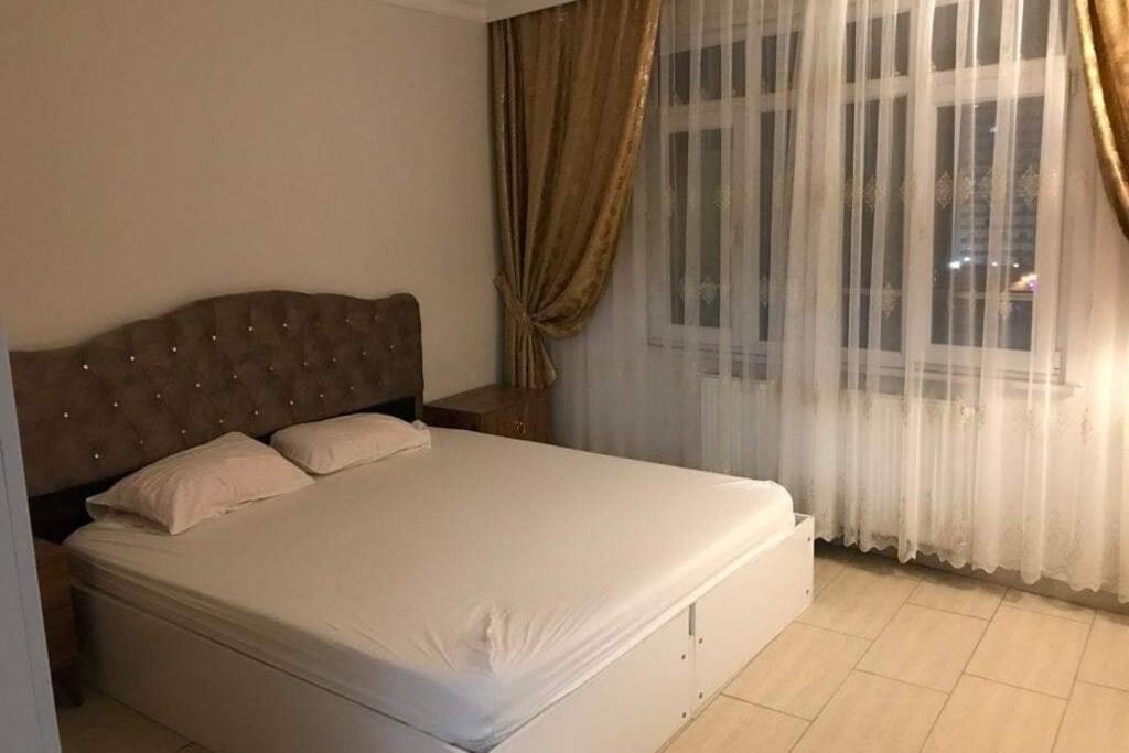 1 dormitorio con 1 cama y una ventana con cortinas en studio, en Estambul