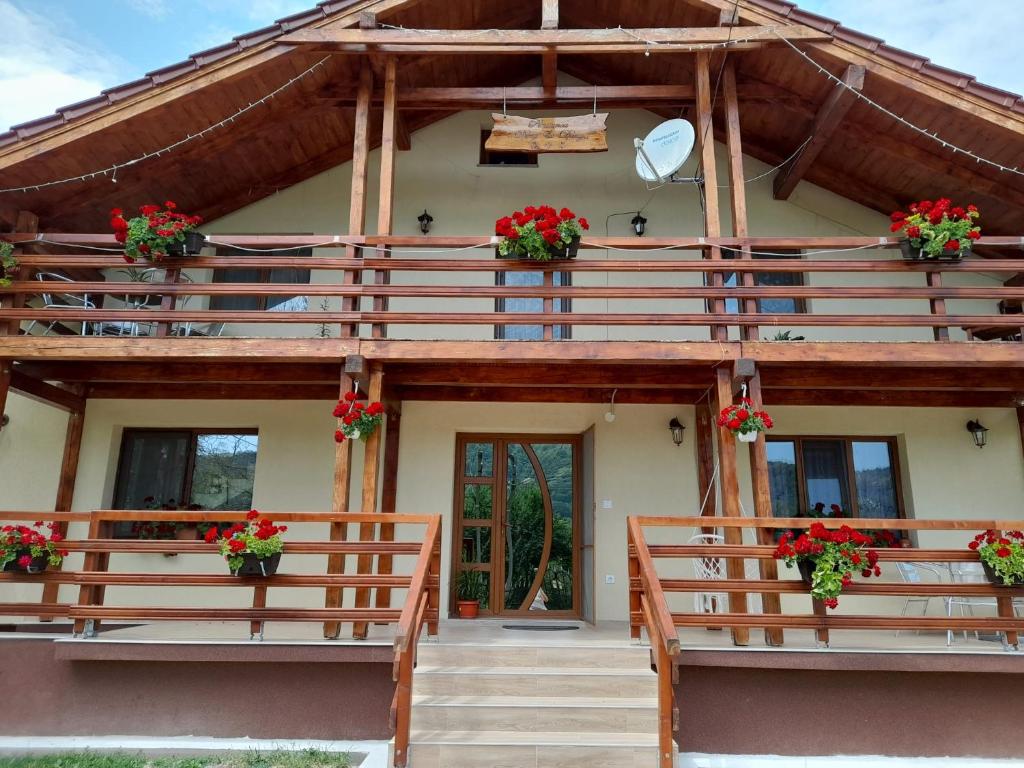 une maison avec des fleurs sur les balcons dans l'établissement Pensiunea Deny şi Dany, à Ribiţa