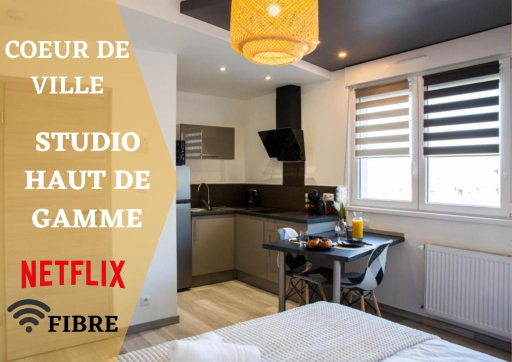 um quarto com uma cozinha com uma mesa e uma cama em Studio Prestige Cœur de Ville em Mulhouse
