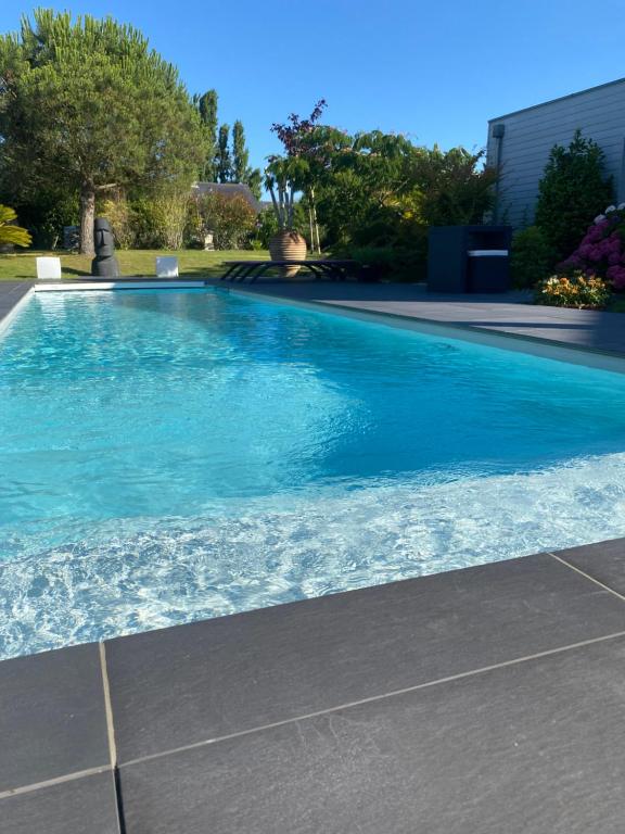 uma grande piscina com água azul em LES EVENS La Baule em La Baule