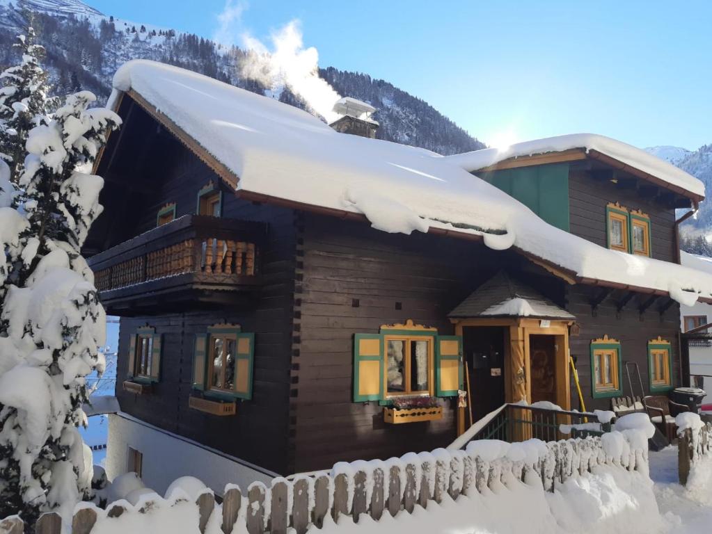 domek z bali i śniegiem na dachu w obiekcie St Anton 365 w mieście Sankt Anton am Arlberg
