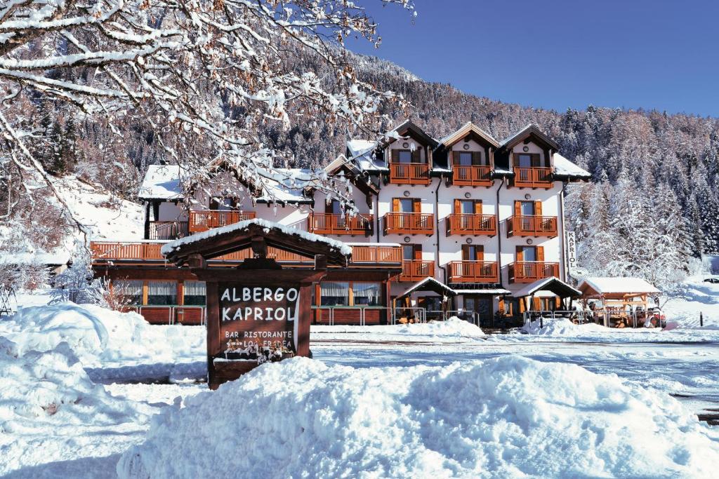 a large building with a sign in the snow at Kapriol in Castello Tesino