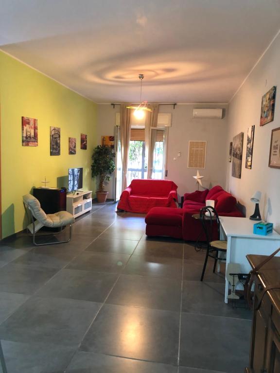 ein Wohnzimmer mit einem roten Sofa und einem Tisch in der Unterkunft Casa Borré in Ercolano