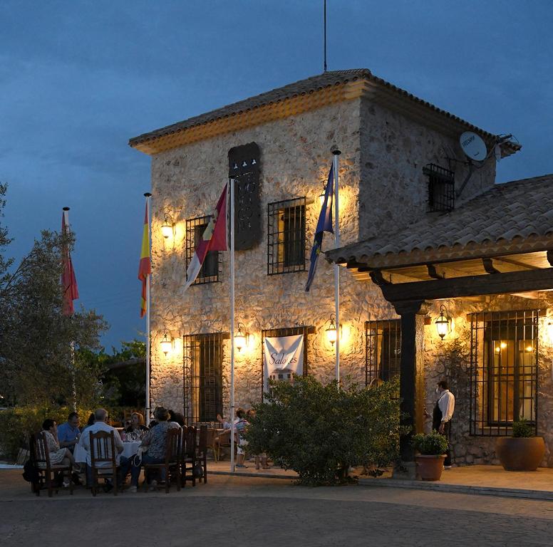 un grupo de personas sentadas fuera de un edificio con banderas en Hotel Rural La Moragona en Vara de Rey